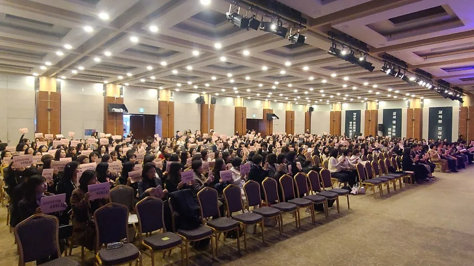 큰 연회장을 채운 참가자들이 손팻말을 들고 무대를 보는 모습을 멀리서 찍은 사진