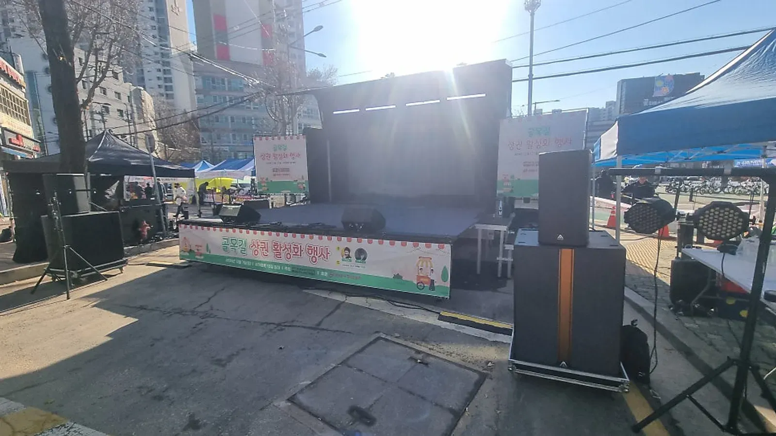 거리에 세운 무대와 양쪽 스피커, 현수막을 단 축제 무대를 행사 전에 찍은 모습